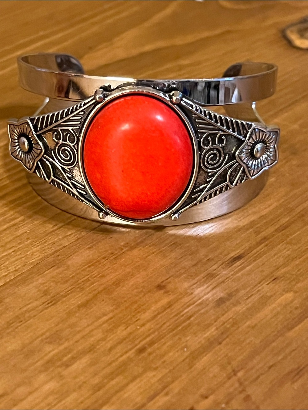 Red like stone on silver tone cuff with intricate design and cut out size 7 1/2”